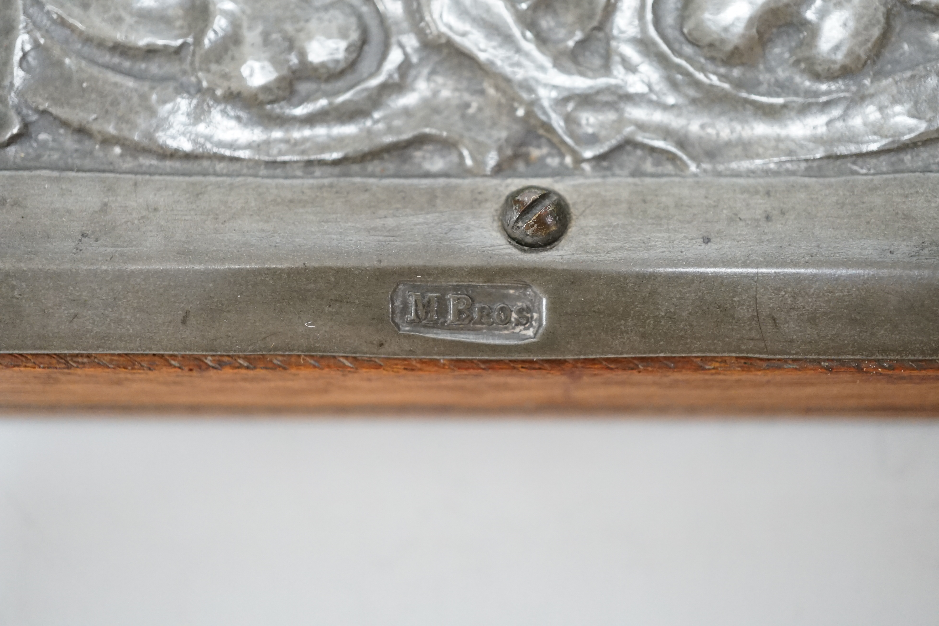 A Miller Brothers Art Nouveau embossed pewter mirror with cabochon turquoise enamel bosses, 48cm high x 39cm wide